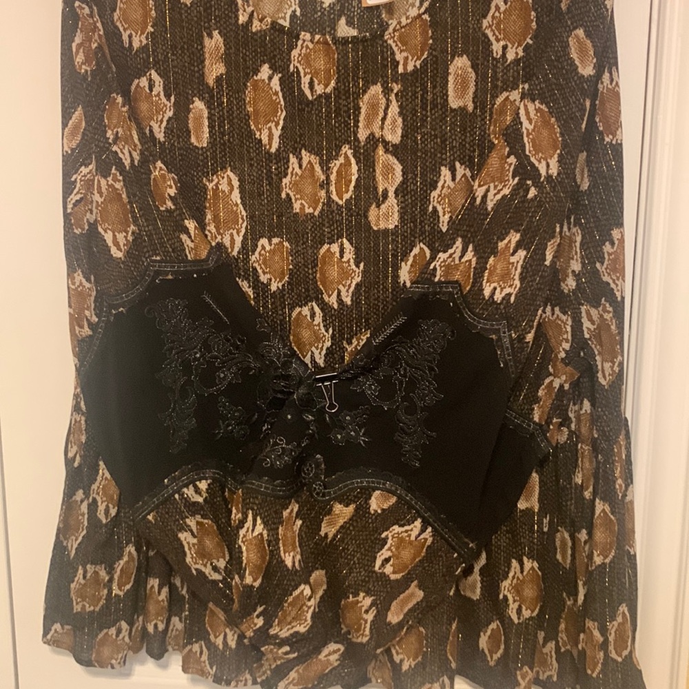 Brown/black top with black lace details on the long sleeves; ruffled bottom